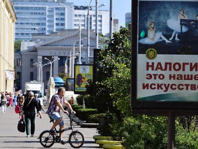 Плакат с надписью "Налоги это наше искусство!" на улице Минска. Фото: Александр Миридонов/Коммерсант